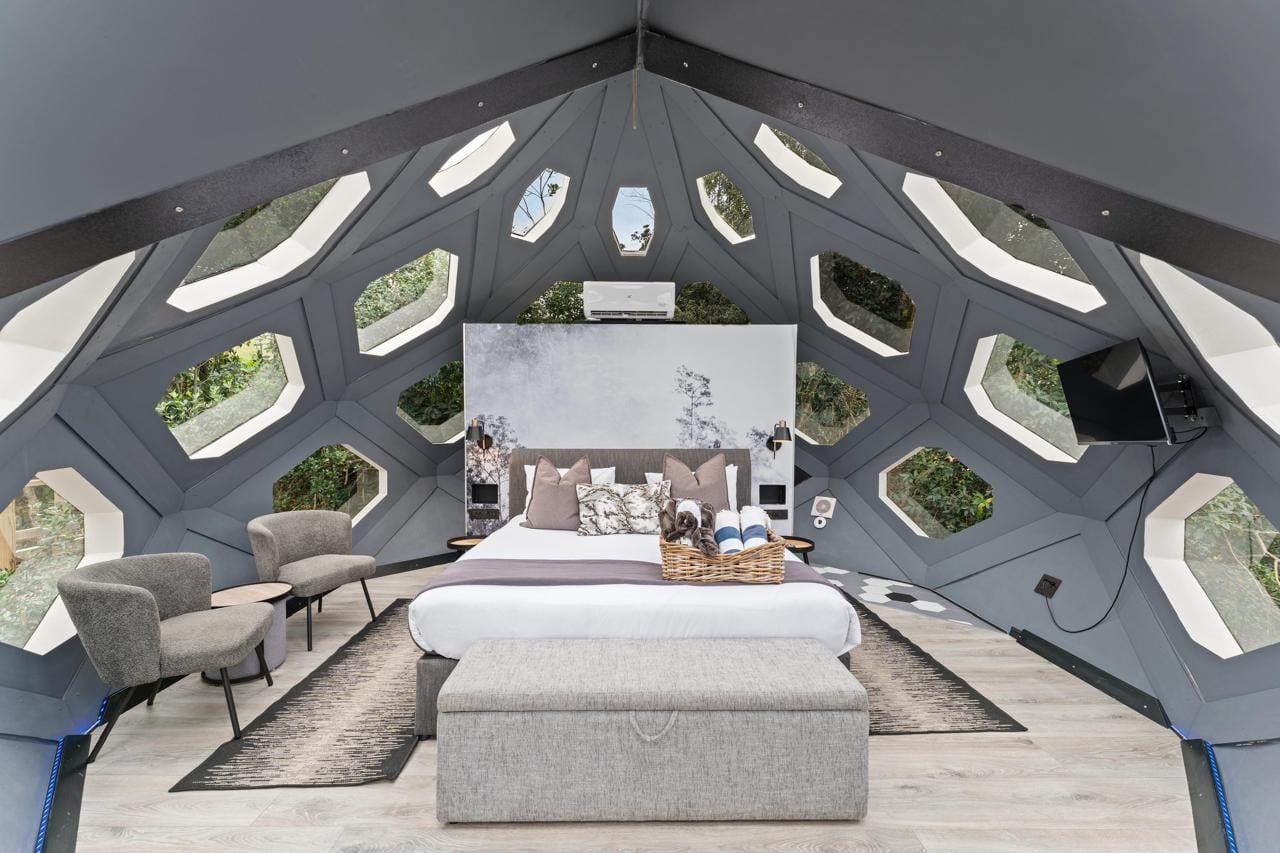 Inside one of The Hives: the bed under one continuous faceted volume, windows on every face